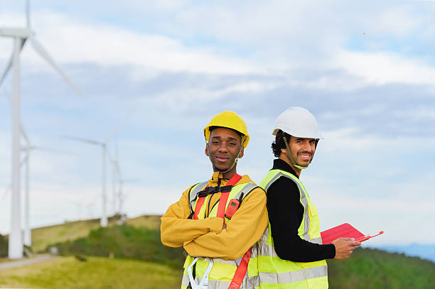 istock Engineers working back to back in a wind turbine farm 2204771016