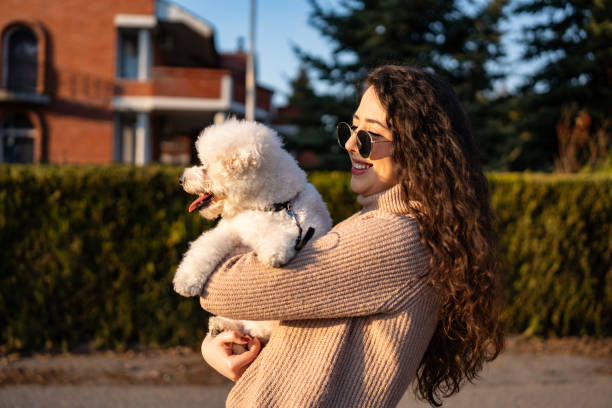 Young Woman Enjoying Time Outdoors With a Small Fluffy White Dog