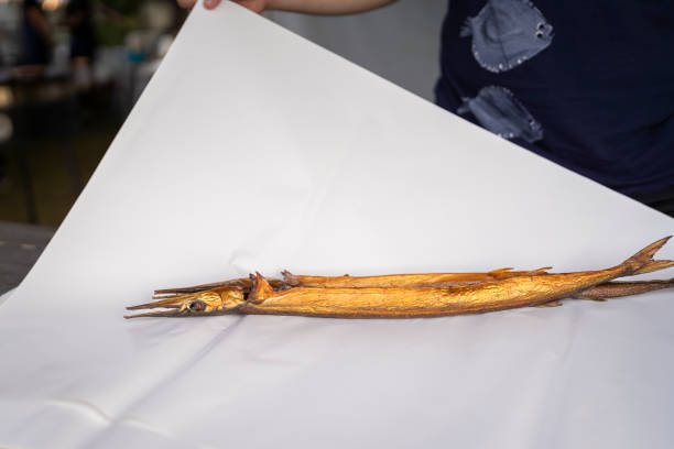 Smoked garfish on a white wrapping paper.