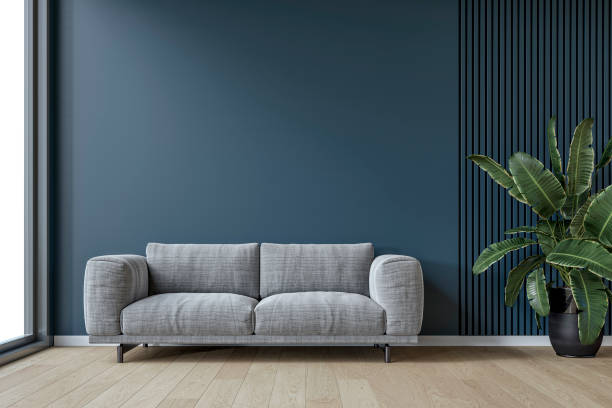 istock A modern minimalist interior with a gray textile sofa, a potted plant in front of an empty deep blue plaster, partly deep green paneled wall background with copy space, a large window by one side 2204777101