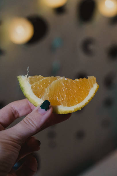 istock Close-Up of Hand Holding Orange Slice 2204779354
