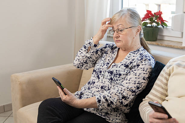 istock Senior woman looking on cell phone at home 2204779727