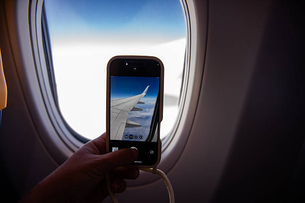 istock Passenger taking photo of airplane wing through window 2204781215