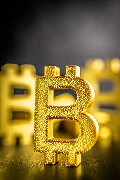 istock Gold bitcoin sign on black table. Gold cryptocurrency on black table. 2204782533