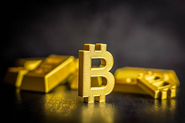 Gold bitcoin sign on black table. Gold cryptocurrency on black table.