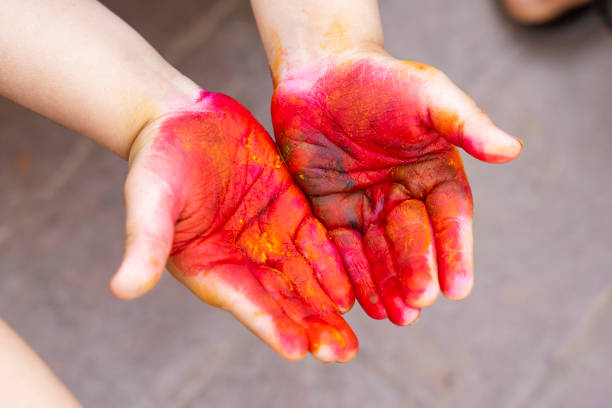 A cute and colorful image of a kid's hand covered in Holi powders. This photo represents the playful and festive spirit of Holi