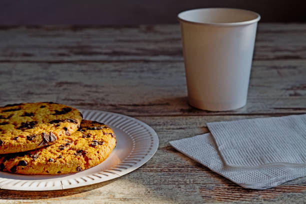 istock Homemade large chocolate cookie, giant chocolate cookie on a disposable plate next to a disposable cup â a hint of a quick yet delicious treat. 2204784474