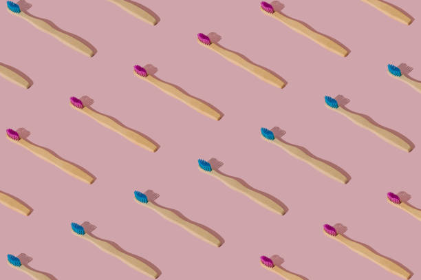 istock Organic bamboo toothbrush pattern composition on pastel pink background. Trendy dental concept. Creative eco friendly, biodegradable and natural wooden toothbrush pattern backdrop idea. 2204786704