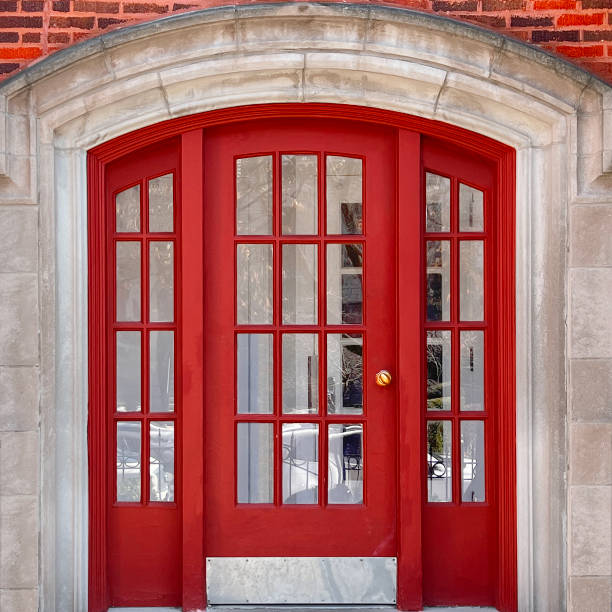 istock Elegant Red French Doors with Arched Stone Frame in Historic Brick Building 2204795964