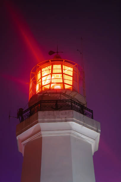 istock Towering lighthouse shines intensely in deep blue night, casting powerful beams of light across sky, embodying resilience, direction, and solitude. Ideal for travel, maritime, and inspirational use 2204797933