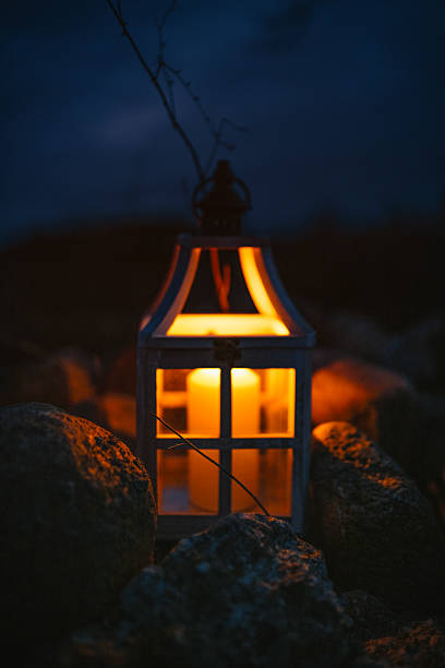 Glowing Lantern with Candle in a Dark Outdoor Setting at Night