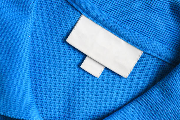 Blank white laundry care clothes label on blue shirt fabric texture background