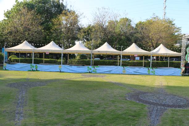 istock A large lawn with three or four canopy tents, white and blue canopies, each tent about five meters long and rectangular in shape. 2204803203