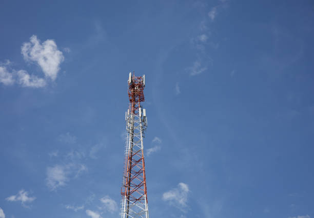 istock White and red communication wave antennas on a blue sky background. 2204804065