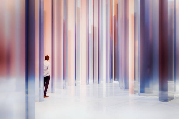 Businessman standing behind glass column