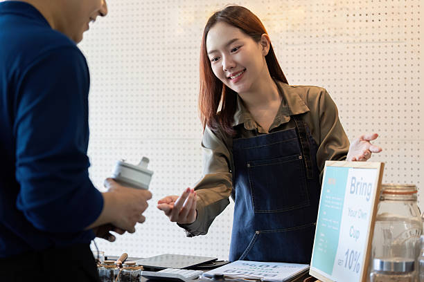 istock Sustainable Customer Engagement. A barista interacting with a customer who brought their reusable cup. 2204807282