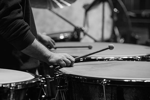 A close-up of a drummer playing on a drum set and cymbals on stage