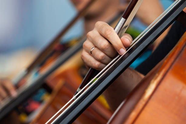 Close-up of a musician's hand playing the cello in an orchestra