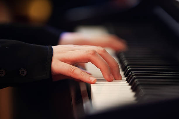 istock Girl's hand on piano keys 2204810692