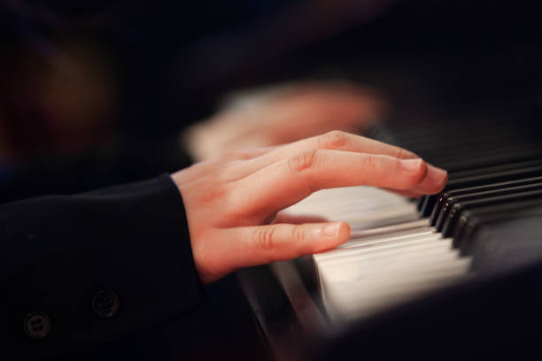 istock Girl's hand on piano keys 2204810695