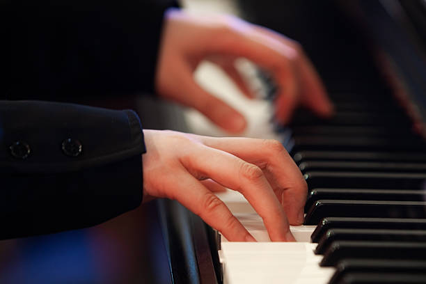 istock Girl's hand on piano keys 2204810698