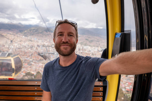 istock Man Taking a Selfie on a Cable Car with Cityscape View 2204818037