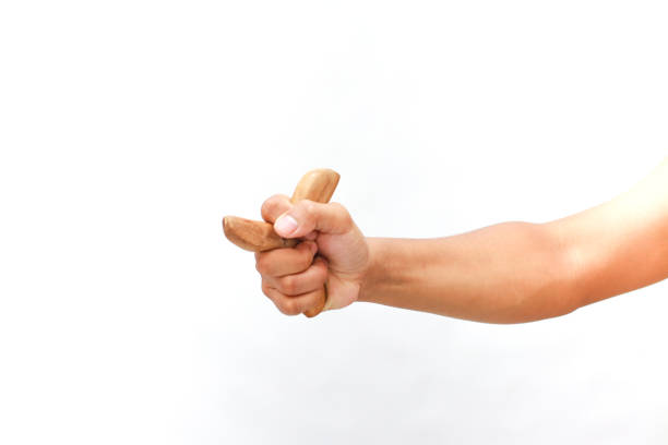 istock A hand holding a wooden acupressure tool against a pristine white backdrop 2204818717