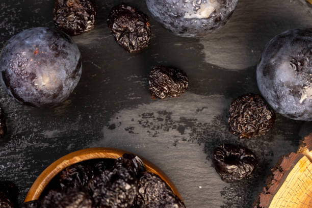 istock ripe purple plums and dried plums 2204823694