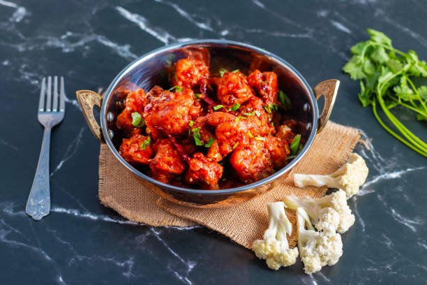 istock Gobi Manchurian is a crispy, spicy Indo-Chinese dish made with battered, fried cauliflower tossed in a tangy, flavorful soy-garlic sauce 2204824201