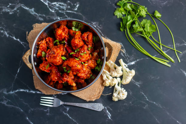 istock Gobi Manchurian is a crispy, spicy Indo-Chinese dish made with battered, fried cauliflower tossed in a tangy, flavorful soy-garlic sauce 2204824237