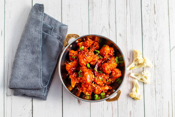 istock Gobi Manchurian is a crispy, spicy Indo-Chinese dish made with battered, fried cauliflower tossed in a tangy, flavorful soy-garlic sauce 2204824307
