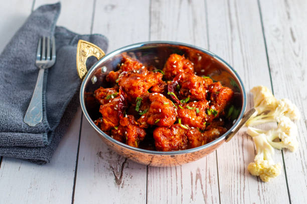 istock Gobi Manchurian is a crispy, spicy Indo-Chinese dish made with battered, fried cauliflower tossed in a tangy, flavorful soy-garlic sauce 2204824308