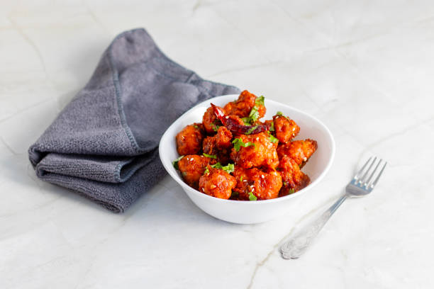 istock Gobi Manchurian is a crispy, spicy Indo-Chinese dish made with battered, fried cauliflower tossed in a tangy, flavorful soy-garlic sauce 2204824342