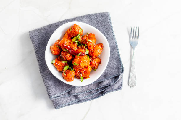 istock Gobi Manchurian is a crispy, spicy Indo-Chinese dish made with battered, fried cauliflower tossed in a tangy, flavorful soy-garlic sauce 2204824391
