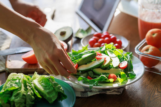 istock Healthy Avocado and Tomato Salad Preparation Using a Digital Tablet for Guidance. 2204824574