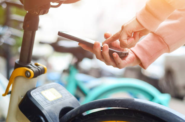 istock A woman uses smart phone to scan the QR code on a shared bike to unlock it. 2204827127