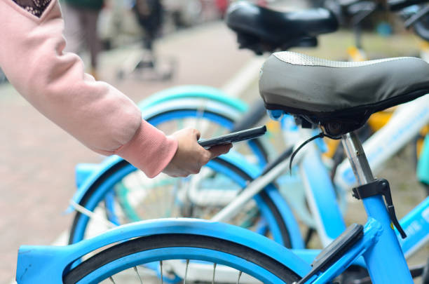 istock A woman uses smart phone to scan the QR code on a shared bike to unlock it. 2204827129