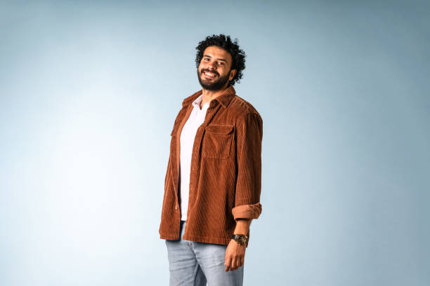 istock Smiling Middle Eastern Man in Casual Brown Jacket Against Light Blue Background 2204829806