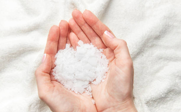 istock Woman holding white magnesium chloride flakes in hands for a relaxing bath 2204831034