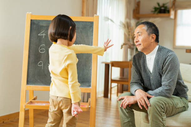 A grandchild studying with his grandfather