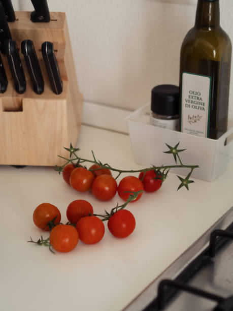 istock Cherry Tomatoes and Wooden Knife Holder on a White Kitchen Counter 2204835586