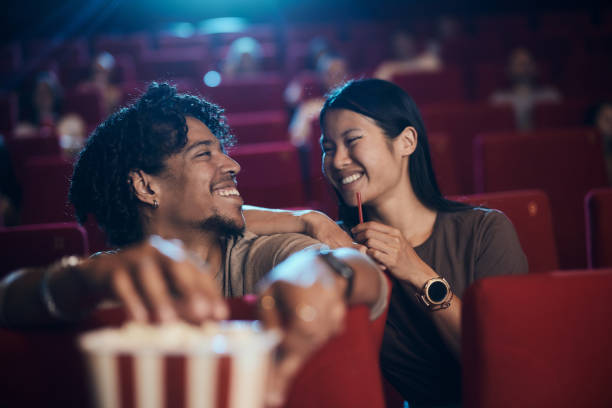 istock Happy diverse couple talking while watching a movie at cinema. 2204837310