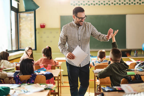 istock Happy teacher and schoolboy giving each other high-five on a class. 2204837976