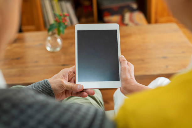 istock An elderly couple using a tablet device in the living room 2204837983