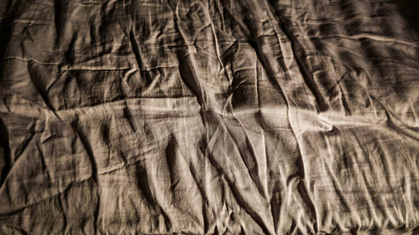 istock A messy bed with wrinkled sheets and high contrast at night 2204843067