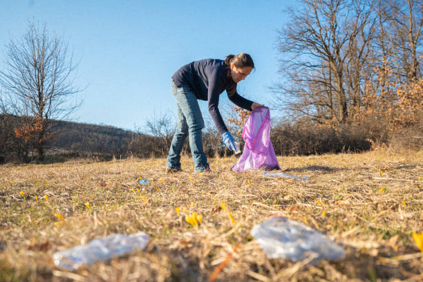 istock Environmental Clean Up.Woman Collecting Garbage In Nature 2204844224