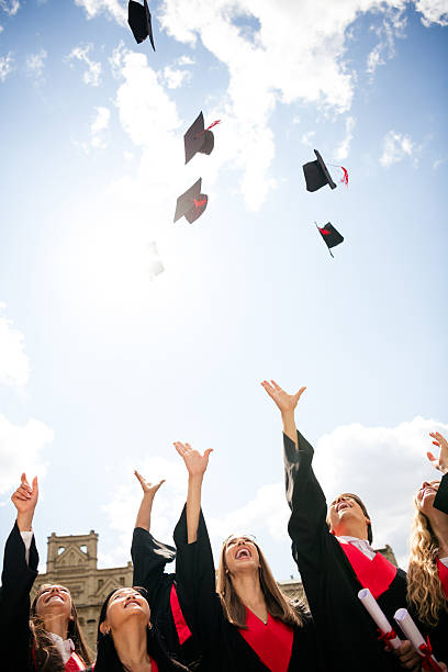 The Silhouette of  graduation group celebrating and jumping on mountain