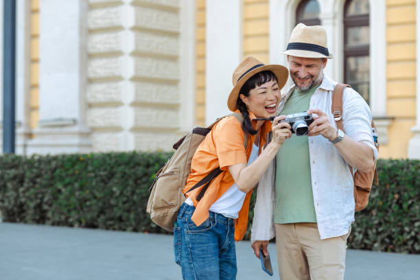 istock Happy couple exploring city together with camera on a sunny day 2204847478