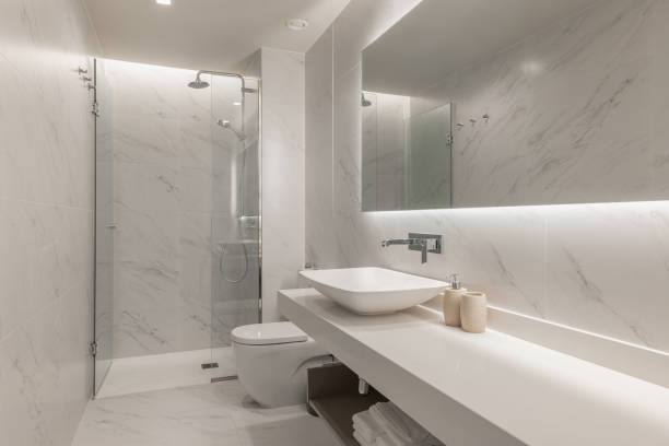 istock Luxury bathroom with marble-effect walls, modern sink, and backlit mirror for a refined look 2204850441