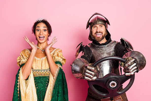 istock Young couple in medieval costumes with modern elements on pink background 2204851277